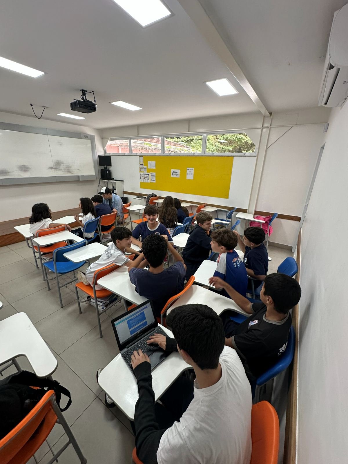 Young people working on projects with laptops in the classroom