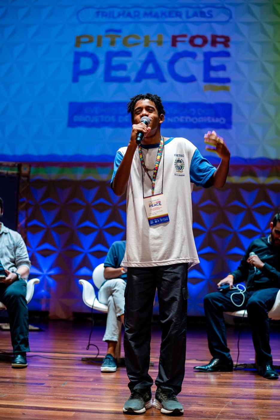 Jovem apresenta o pitch no palco do Pitch for Peace