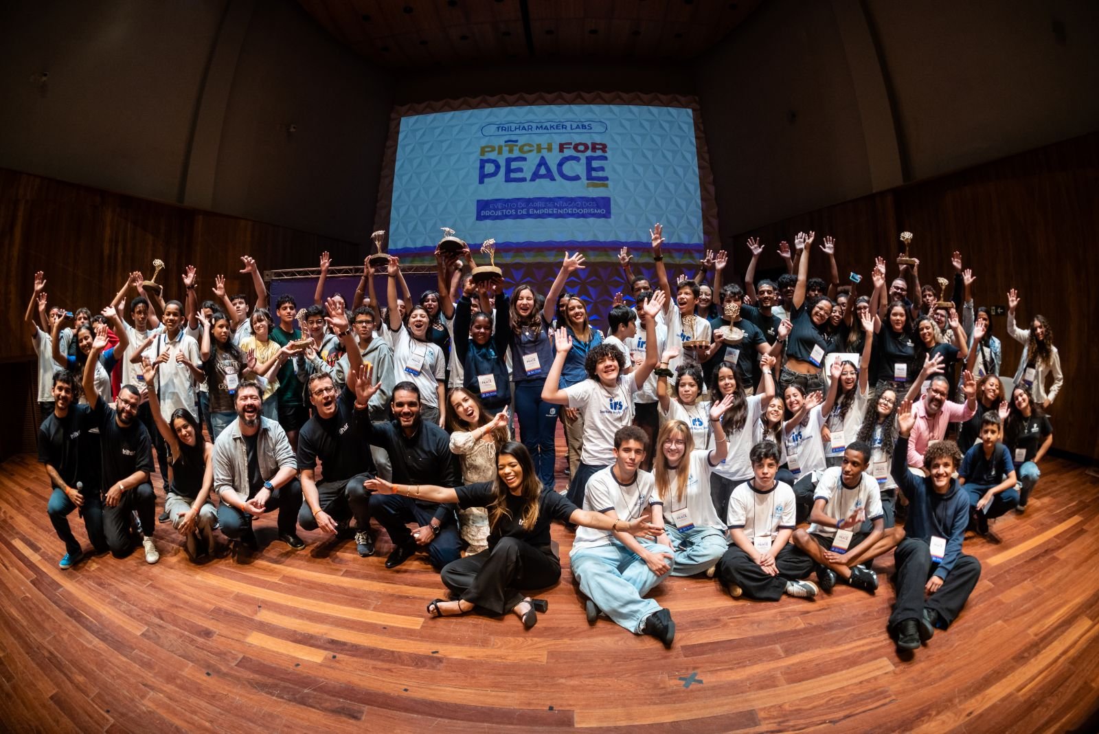 Jovens comemorando juntos no palco do Pitch for Peace